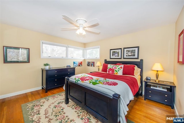 bedroom featuring ceiling fan, baseboards, and wood finished floors