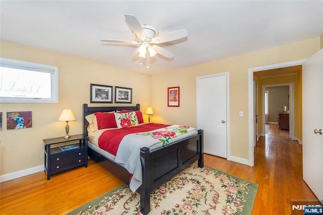 bedroom featuring baseboards, wood finished floors, and a ceiling fan