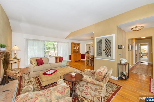 living area with a chandelier, baseboards, and wood finished floors