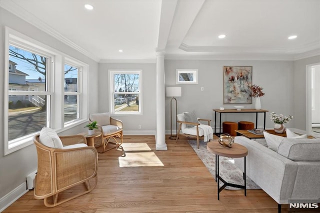 living room featuring crown molding, light wood-style floors, baseboards, and ornate columns