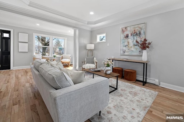 living room featuring ornate columns, wood finished floors, baseboards, and baseboard heating