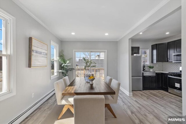 dining area featuring baseboards, light wood-style flooring, recessed lighting, crown molding, and baseboard heating