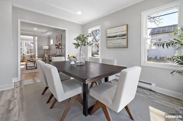 dining space with light wood-type flooring, recessed lighting, crown molding, a baseboard radiator, and baseboards