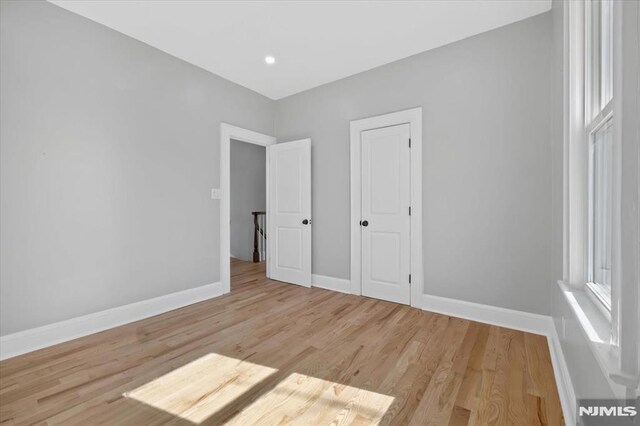 unfurnished bedroom featuring light wood-style flooring and baseboards