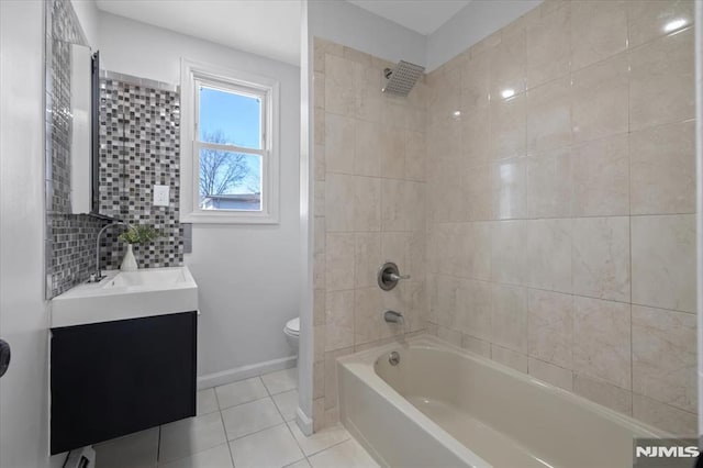 bathroom with tile patterned floors, toilet, washtub / shower combination, baseboards, and vanity