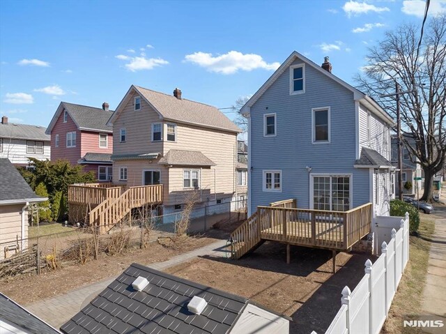 back of property with stairs, a fenced backyard, a chimney, and a wooden deck