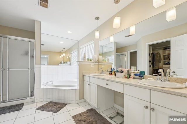 bathroom featuring double vanity, a stall shower, a sink, a garden tub, and tile patterned floors