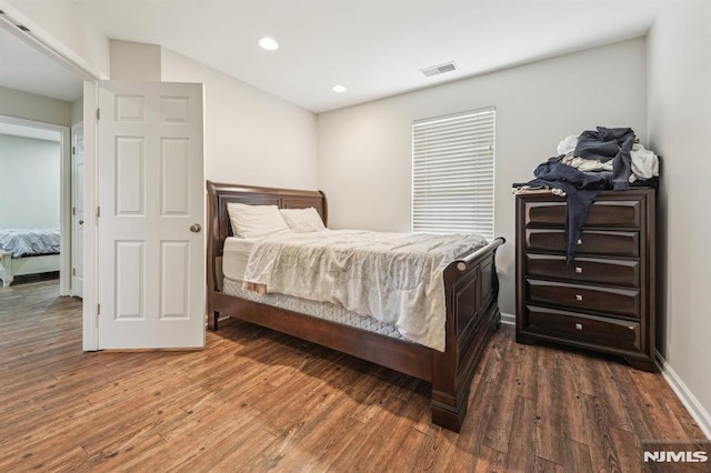 bedroom with dark wood-type flooring, recessed lighting, baseboards, and visible vents