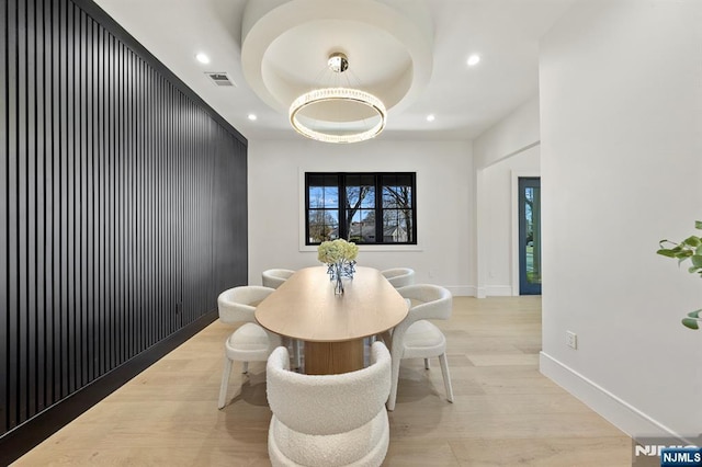 dining space featuring visible vents, baseboards, a tray ceiling, light wood-style flooring, and recessed lighting