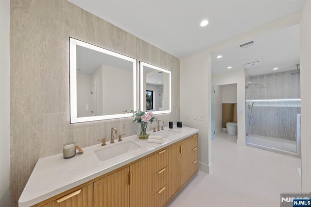 full bath with double vanity, visible vents, a stall shower, and a sink