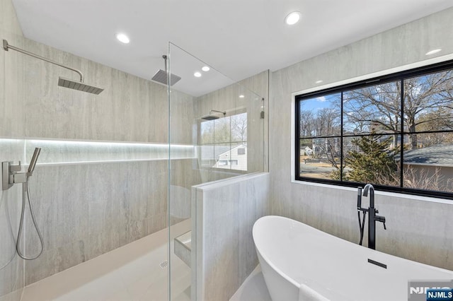 full bath featuring a soaking tub, recessed lighting, a stall shower, and tile walls