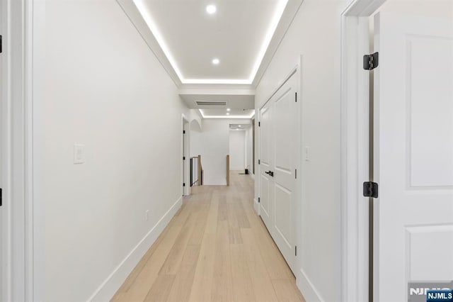 corridor featuring recessed lighting, an upstairs landing, light wood-type flooring, and baseboards