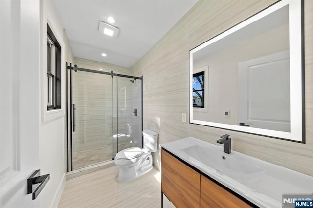 bathroom with toilet, recessed lighting, tile walls, a shower stall, and vanity