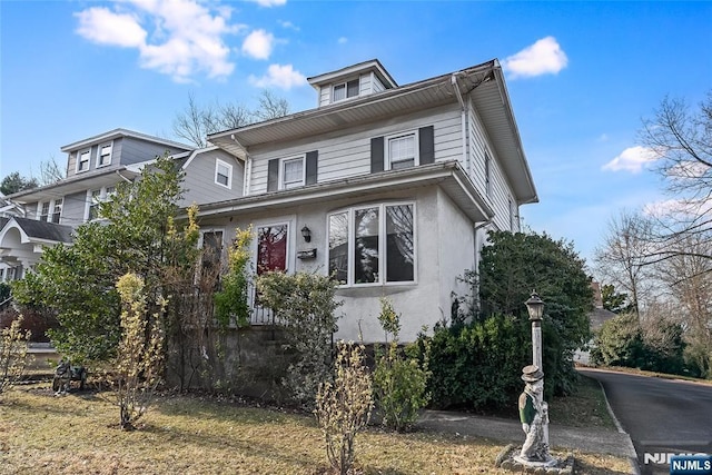 american foursquare style home with stucco siding