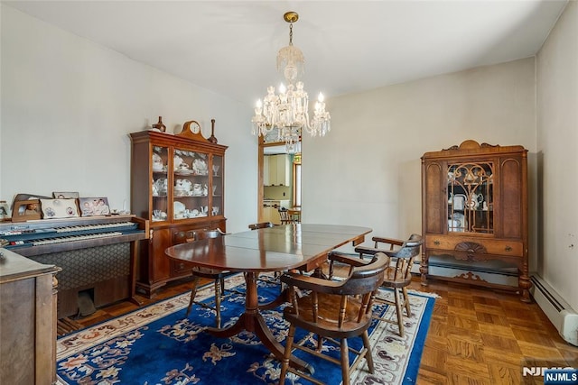 dining area with a chandelier and a baseboard heating unit