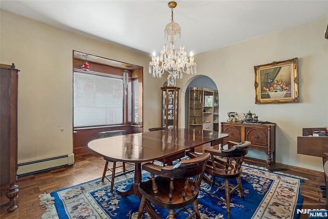 dining area with arched walkways, a notable chandelier, a baseboard heating unit, and baseboards