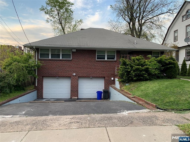 view of front of house featuring brick siding, driveway, and a garage