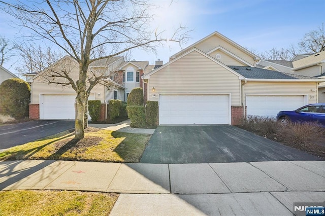 view of front of home with aphalt driveway and brick siding