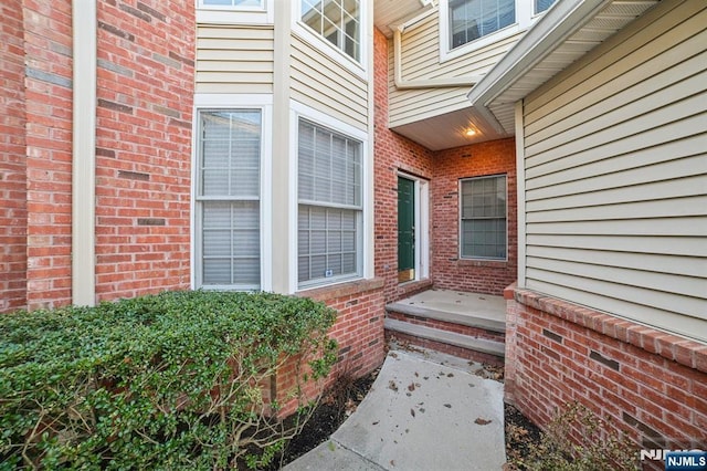 view of exterior entry featuring brick siding