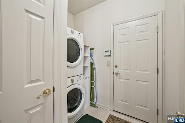 washroom with light tile patterned floors, laundry area, and stacked washing maching and dryer