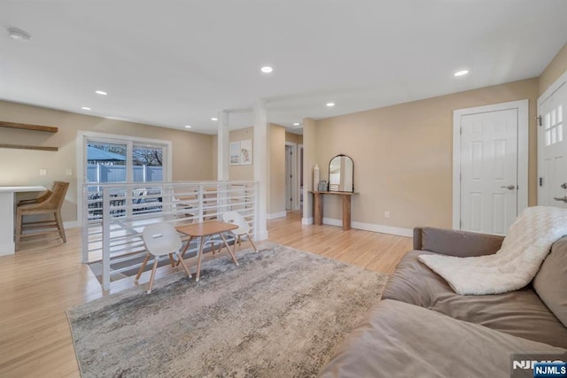 living area featuring recessed lighting, a healthy amount of sunlight, baseboards, and wood finished floors