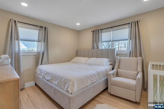 bedroom with light wood-style flooring, multiple windows, and recessed lighting