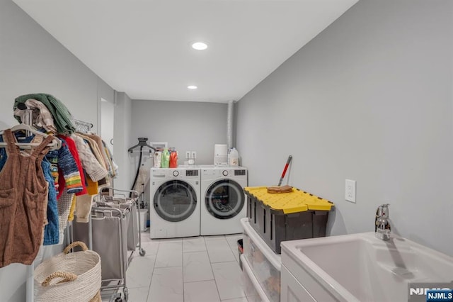 clothes washing area featuring washing machine and dryer, laundry area, recessed lighting, marble finish floor, and a sink