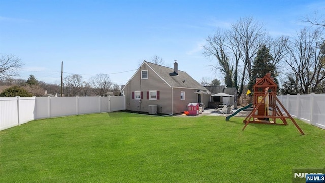 view of yard with cooling unit, a patio, a fenced backyard, and a playground