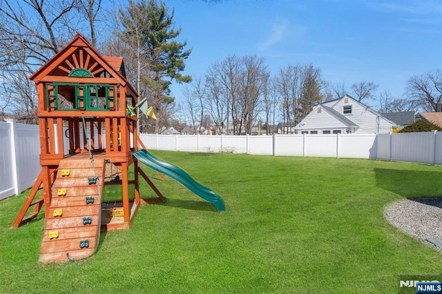 view of jungle gym featuring a lawn and a fenced backyard