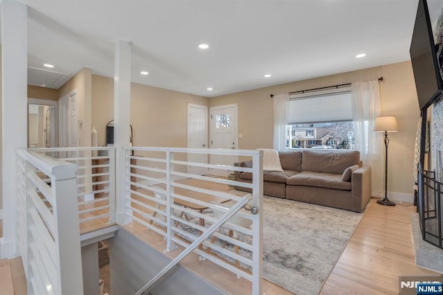 living area with attic access, recessed lighting, wood finished floors, and baseboards