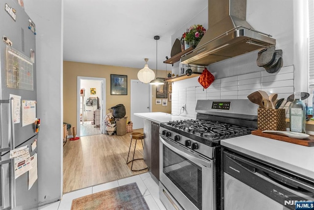 kitchen featuring tasteful backsplash, appliances with stainless steel finishes, light tile patterned flooring, light countertops, and extractor fan