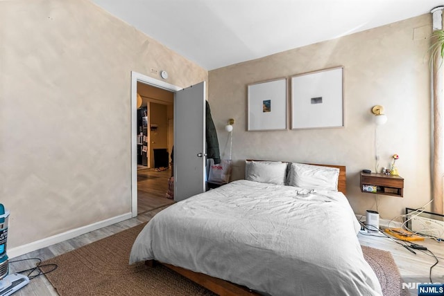 bedroom with baseboards and wood finished floors