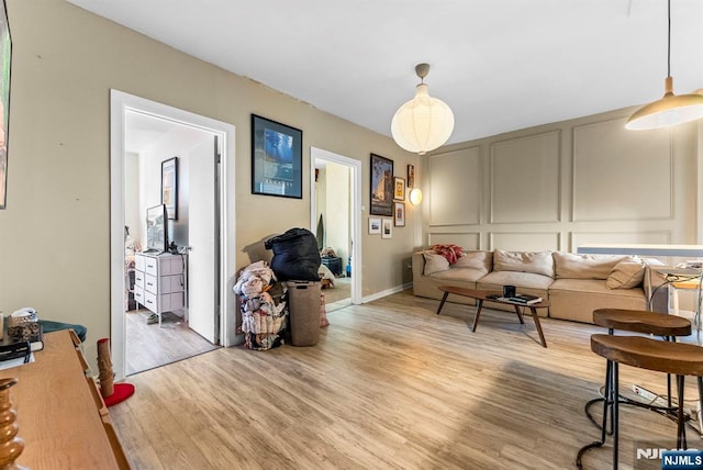 living area with a decorative wall and light wood-type flooring