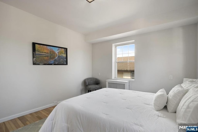 bedroom with wood finished floors and baseboards