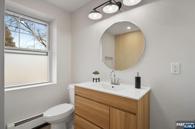 half bath featuring vanity, toilet, and a baseboard radiator