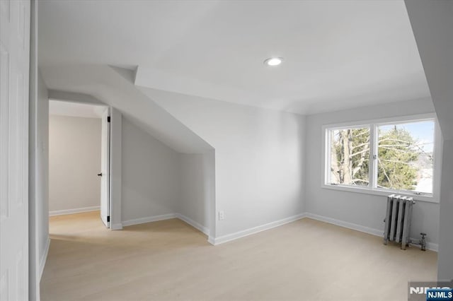 bonus room featuring recessed lighting, radiator heating unit, light wood-style floors, and baseboards