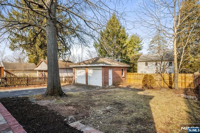 view of yard featuring a detached garage, fence private yard, and an outdoor structure