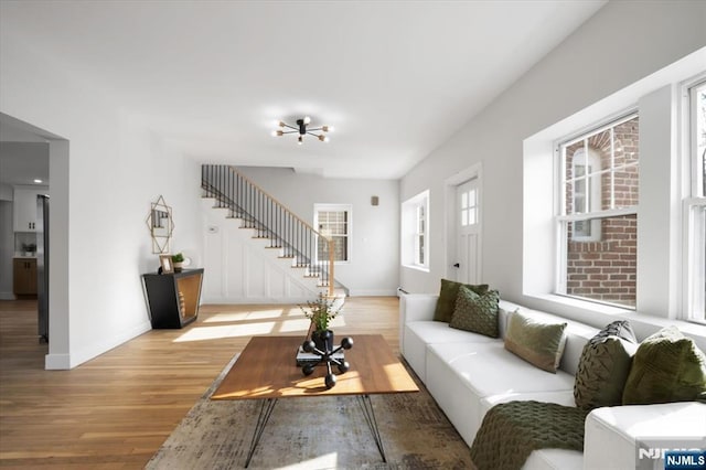 living room with stairs, wood finished floors, and baseboards