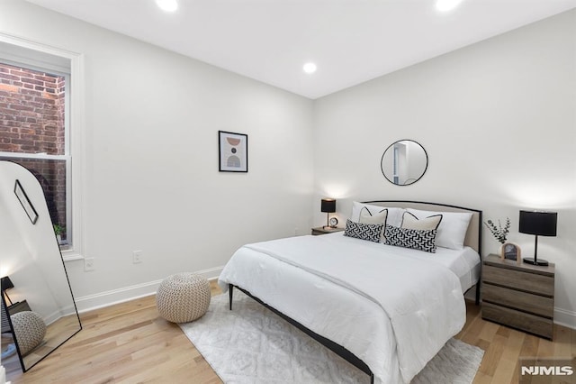 bedroom with recessed lighting, light wood-style floors, and baseboards