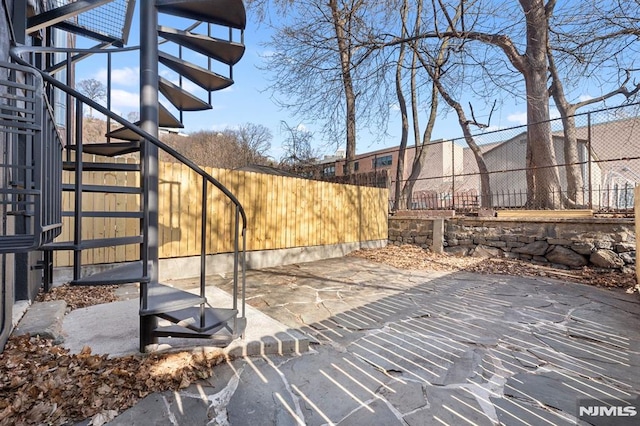 view of patio / terrace featuring stairs and a fenced backyard