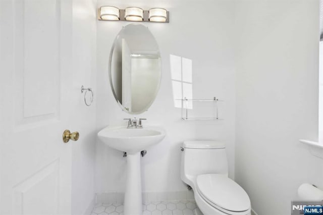 bathroom with toilet and baseboards