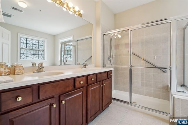 bathroom with tile patterned flooring, a stall shower, visible vents, and a sink