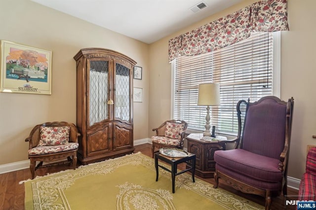 living area with wood finished floors, baseboards, visible vents, and french doors