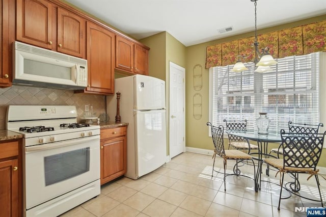 kitchen with visible vents, a notable chandelier, pendant lighting, white appliances, and decorative backsplash