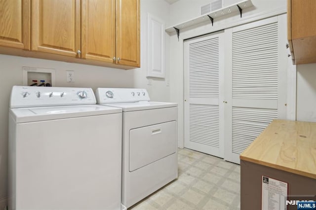 clothes washing area featuring cabinet space, visible vents, light floors, and washing machine and dryer