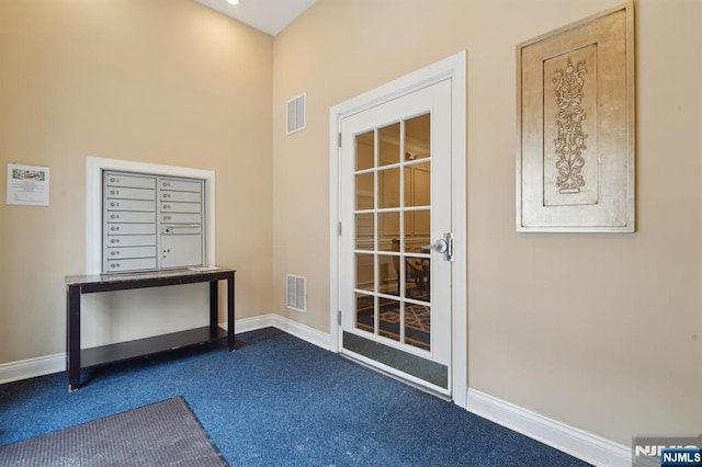 doorway to outside featuring visible vents, baseboards, and dark colored carpet