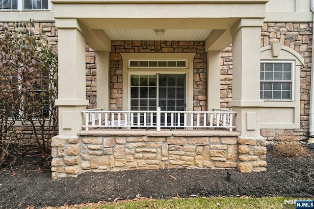 property entrance featuring stone siding and a porch