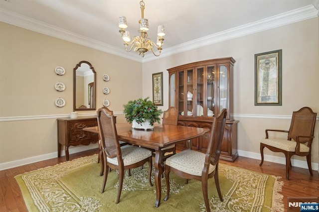 dining space with a notable chandelier, wood finished floors, and baseboards