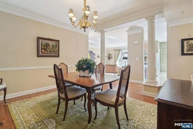 dining space with baseboards, a chandelier, ornamental molding, wood finished floors, and ornate columns