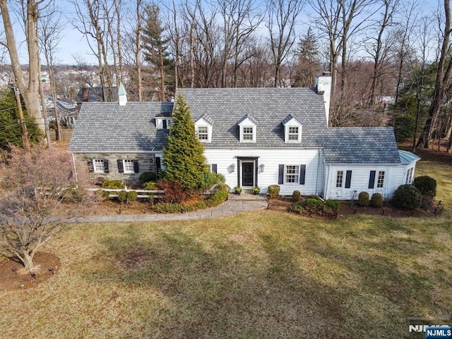 cape cod house with a chimney and a front lawn